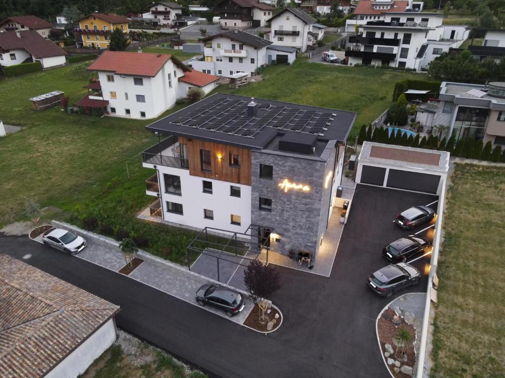 an aerial view of a house with cars parked in a parking lot at Aenna Apart Prutz in Prutz