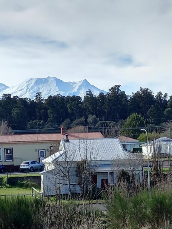 a house with snow capped mountains in the background at Rimu in Ohakune