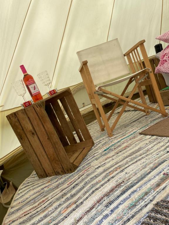 a table and a chair on top of a rug at Brambles Bell Tent in Carmarthen