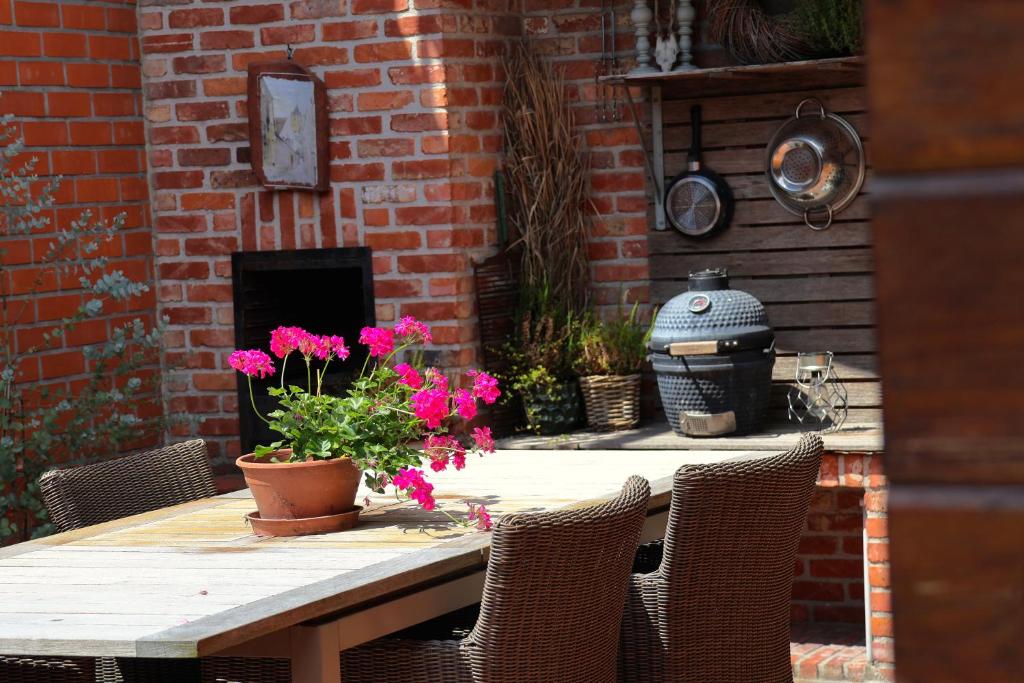 un tavolo in legno con fiori in cima a un muro di mattoni di House Rhodopi a Maldegem