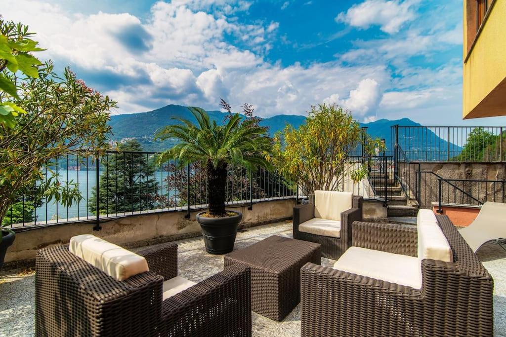 een patio met stoelen en uitzicht op het water bij Sun Luxury Apartment with Swimming Pool - Blevio in Blevio