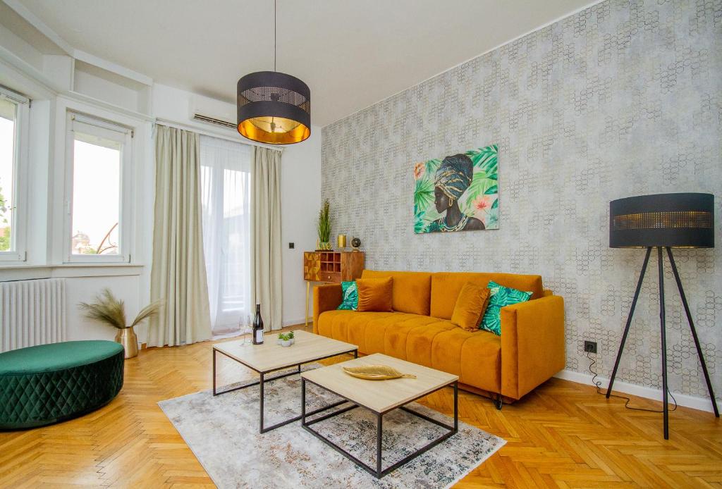 ブダペストにあるAnthony's Apartment With Balcony in Downtownのリビングルーム(オレンジ色のソファ、テーブル付)