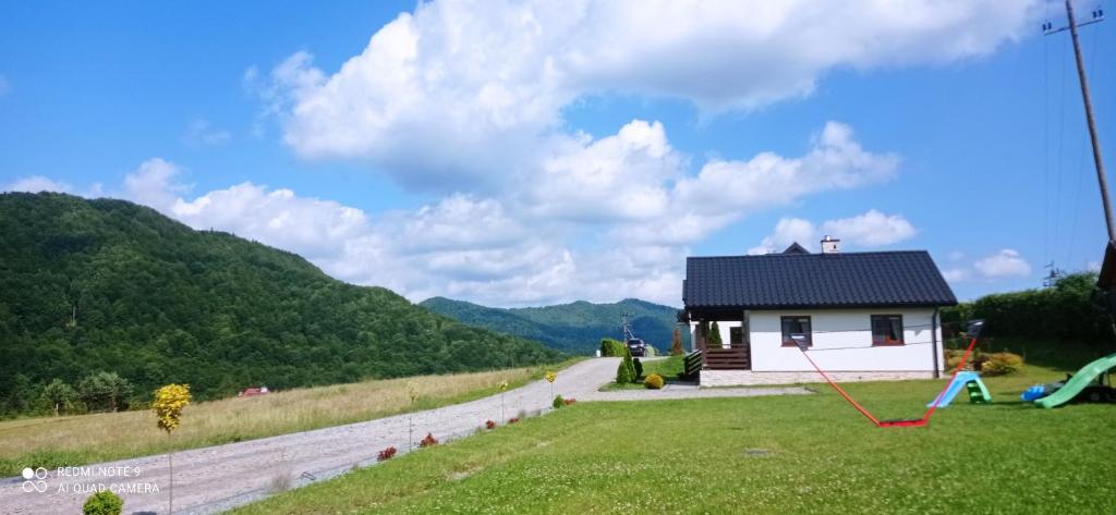 a small house in the middle of a field at Domki Wichrowe Wzgórze Bieszczady in Bukowiec