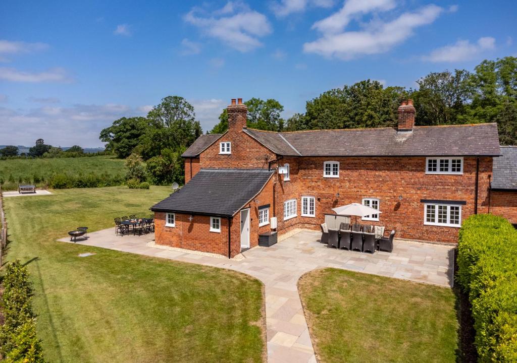 uma vista aérea de uma casa de tijolos com um pátio em The Farmhouse at Marrington Estate em Chirbury