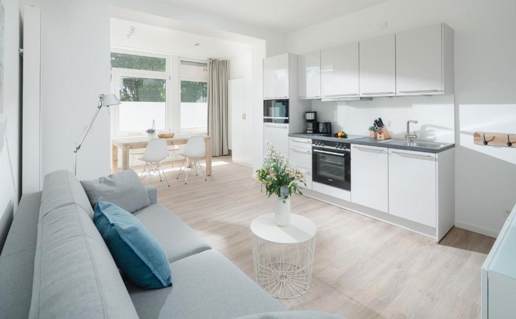 uma sala de estar e cozinha com um sofá e uma mesa em Strandloft Eins Norderney em Norderney