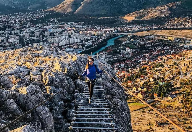 a woman walking up some stairs on a mountain at Apartman ASI in Mostar