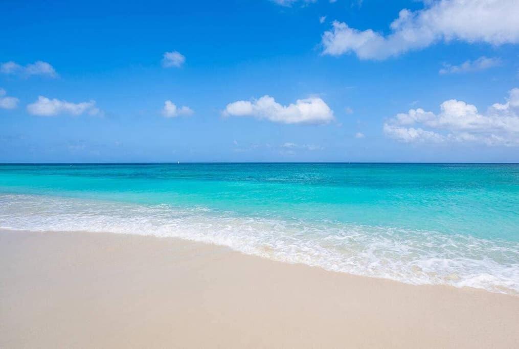 a beach with the ocean and a blue sky at Beach Living at Island Pine Villas BLP in George Town