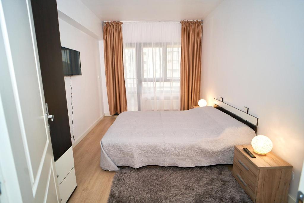Habitación blanca con cama y ventana en Stylish and Spacious Apartment in Iasi Fusion Towers, en Iaşi