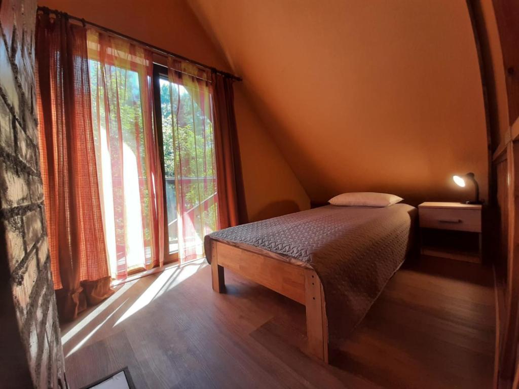 ein Schlafzimmer mit einem Bett und einem großen Fenster in der Unterkunft Ceļinieks in Babīte