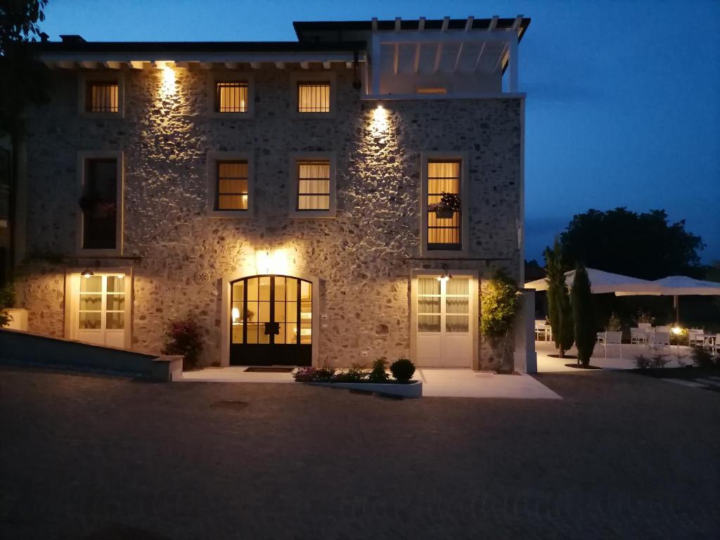 a large stone building with lights on it at night at Relais Ca' Morenica in Valeggio sul Mincio