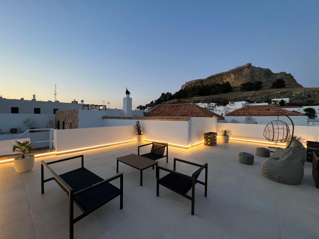a patio with chairs and tables on a roof at Althea Villa in Lindos