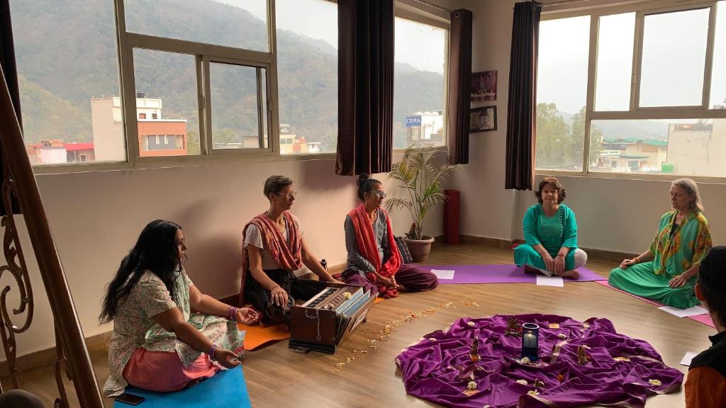 um grupo de pessoas sentadas no chão em uma sala em Rudram Hotel Yoga & Ayurveda Retreat em Rishikesh