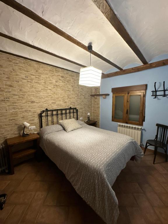 a bedroom with a bed and a brick wall at Casa Maria en Linarejos in Orcera