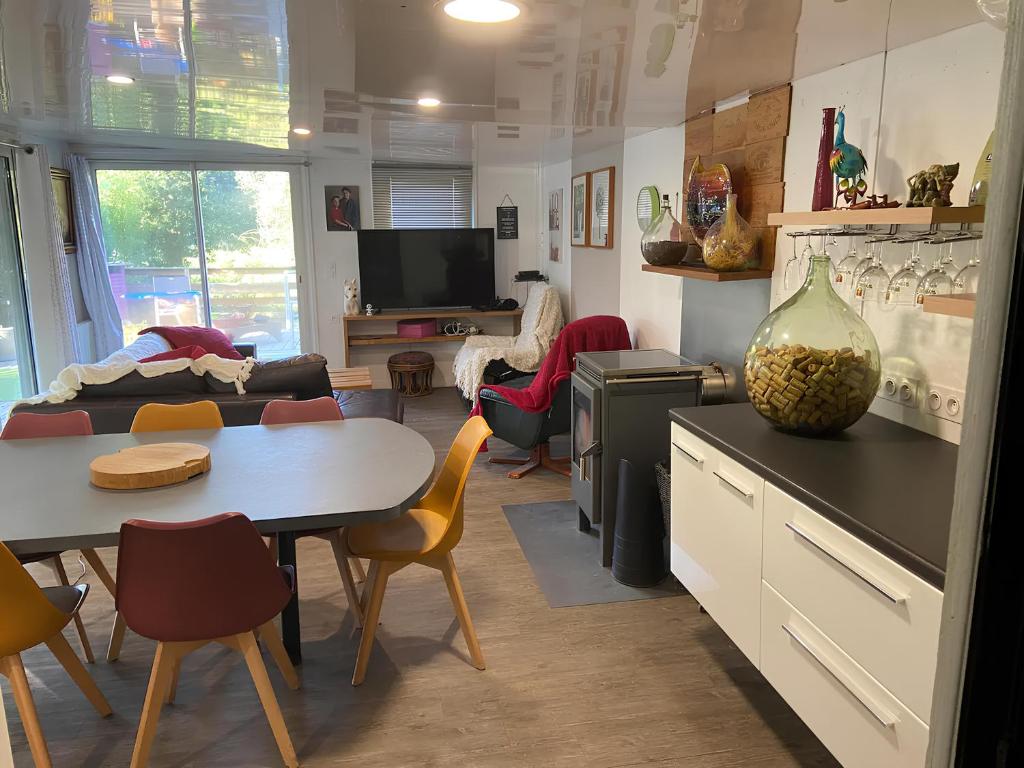uma cozinha com mesa e cadeiras e uma sala de estar em La Paillotte - 6 personnes em Pommeret