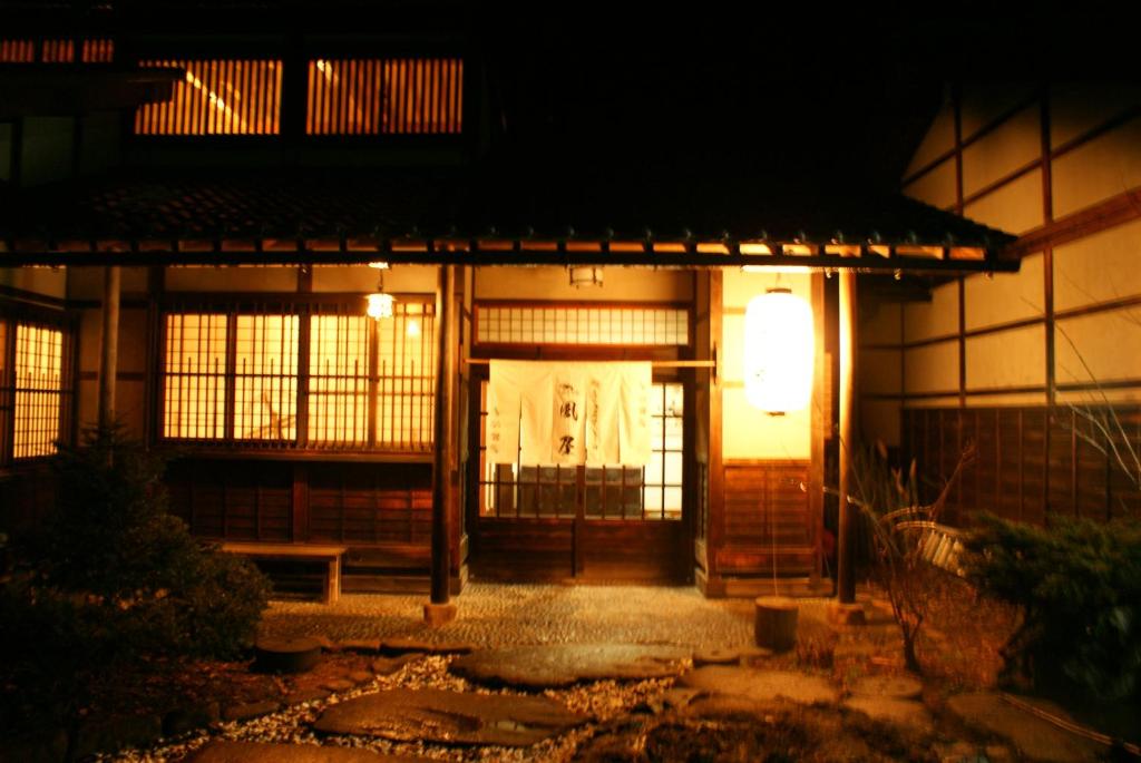 an entrance to a building with a light at night at Kazeya in Takayama