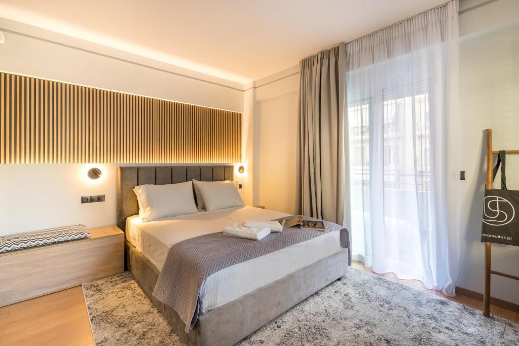 Cette chambre comprend un lit et une grande fenêtre. dans l'établissement Urban suites- HELEXPO, à Thessalonique