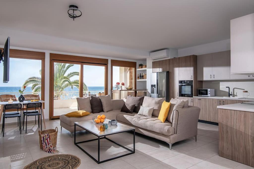 una sala de estar con sofá y una cocina con el océano en Beachfront Orange apt-Ligaria Beach en Lygaria