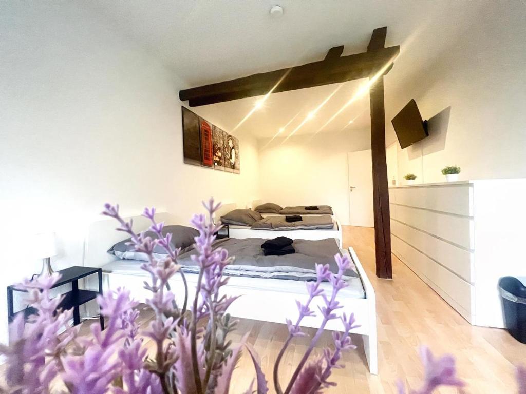 1 dormitorio con cama y flores púrpuras en Workers apartment in Todendorf, en Todendorf