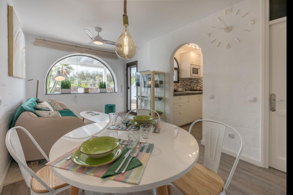 a kitchen and living room with a white table and chairs at in front of the pool, large terrace, elegant & confortable, Wi-Fi in Costa Calma