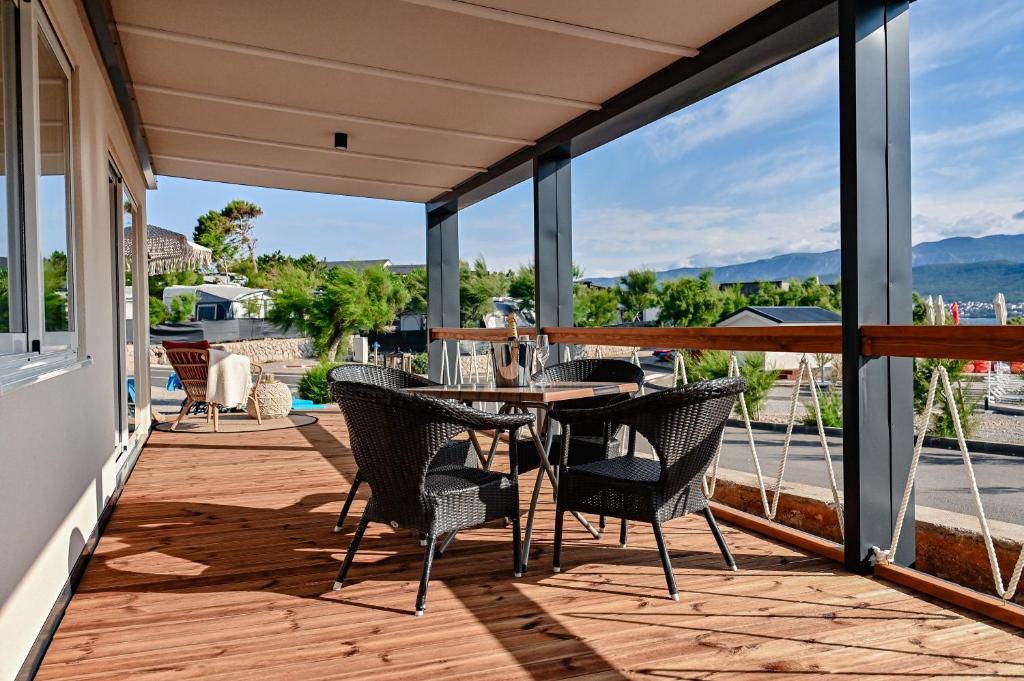 eine Terrasse mit einem Tisch und Stühlen auf dem Balkon in der Unterkunft Mobile Homes Krk Silo in Šilo