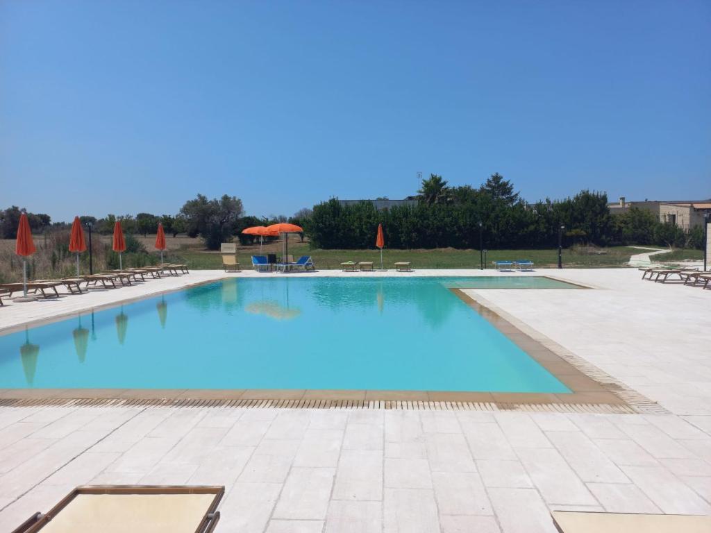 une grande piscine d'eau bleue dans l'établissement Masseria Cricelli, à Lizzanello