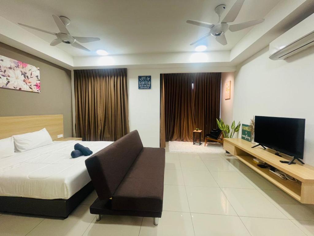 Schlafzimmer mit einem Bett und einem Flachbild-TV in der Unterkunft Melaka Town Homestay Bali Residences Apartment in Malakka