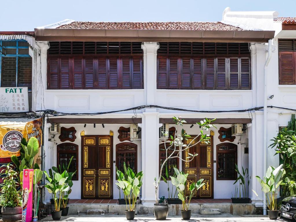 a white building with wooden doors and plants at Carnarvon Antique Loft in George Town