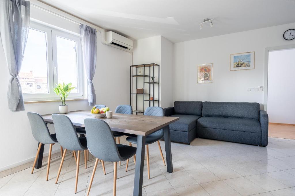 - un salon avec une table, des chaises et un canapé dans l'établissement Charmante Wohnung fußläufig zum Meer in Funtana, à Funtana