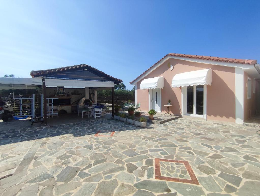 a house with a patio with a table and chairs at Feels like home. in Koukounariá