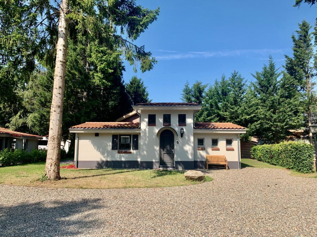 une maison blanche avec un arbre dans l'allée dans l'établissement Boshof 5 in bosrijke, rustige omgeving!, à Ermelo