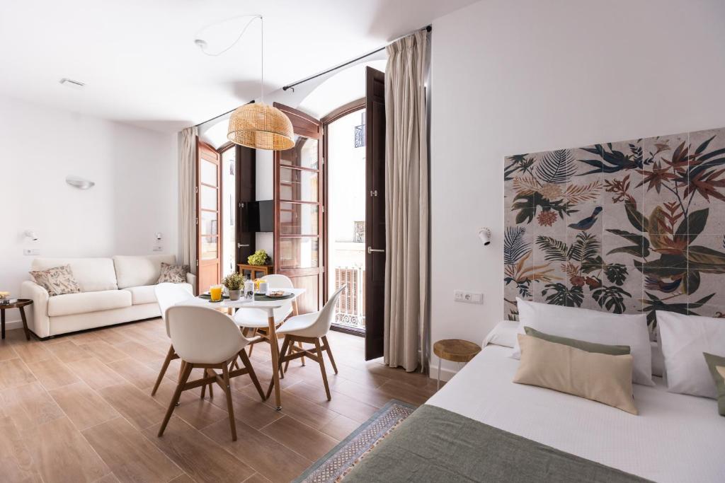 a living room with a bed and a table at Apartamento Especería Green by #CuatroCallesFlats in Málaga