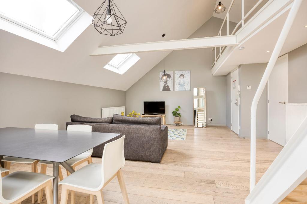uma sala de jantar e sala de estar com mesa e cadeiras em Smartflats - Rubens Antwerp em Antuérpia