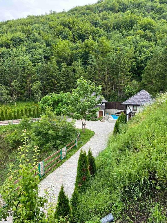 a view of a garden with a house and trees at Azra River View House in Bihać