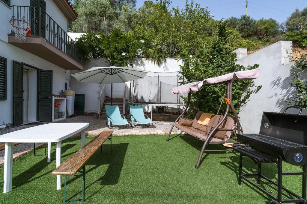 a patio with a table and chairs and an umbrella at Domo de Ro' in Onifai