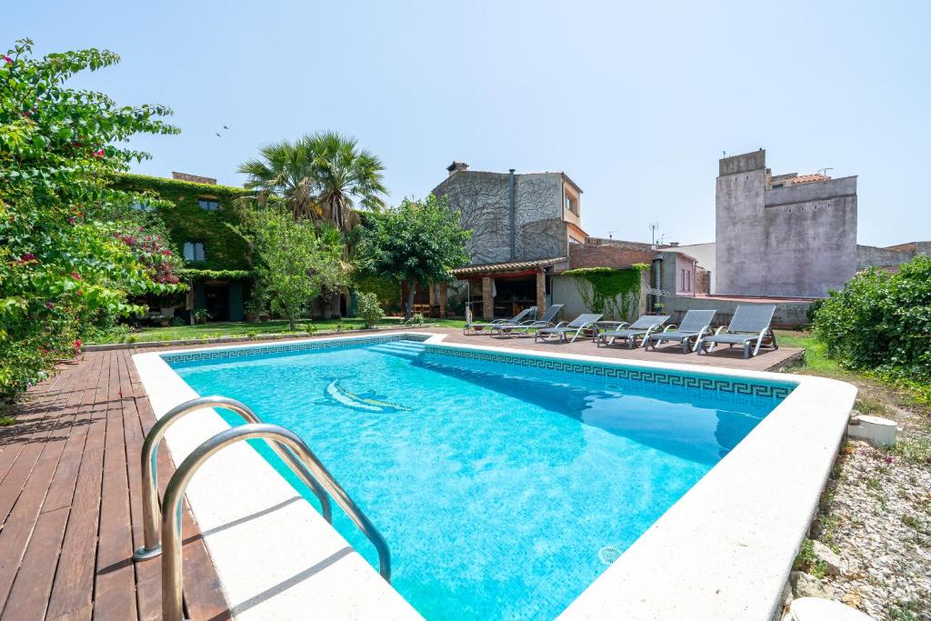 a swimming pool with chairs next to a house at Bonastre in Bonastre