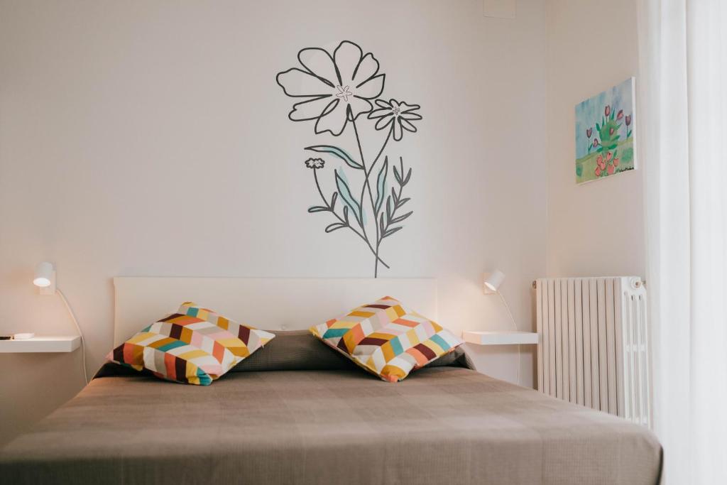 ein Schlafzimmer mit einem Bett mit einer Blume an der Wand in der Unterkunft MAF B&B in Cupello
