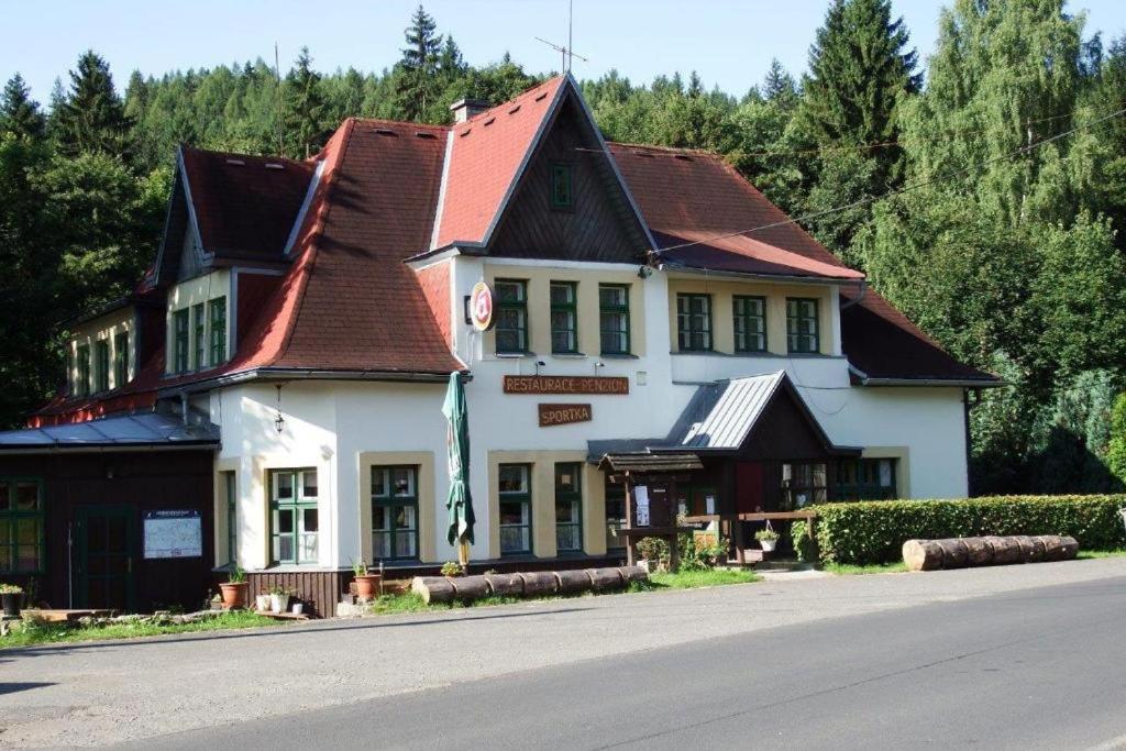 a large white building with a brown roof at Penzion Sportka 