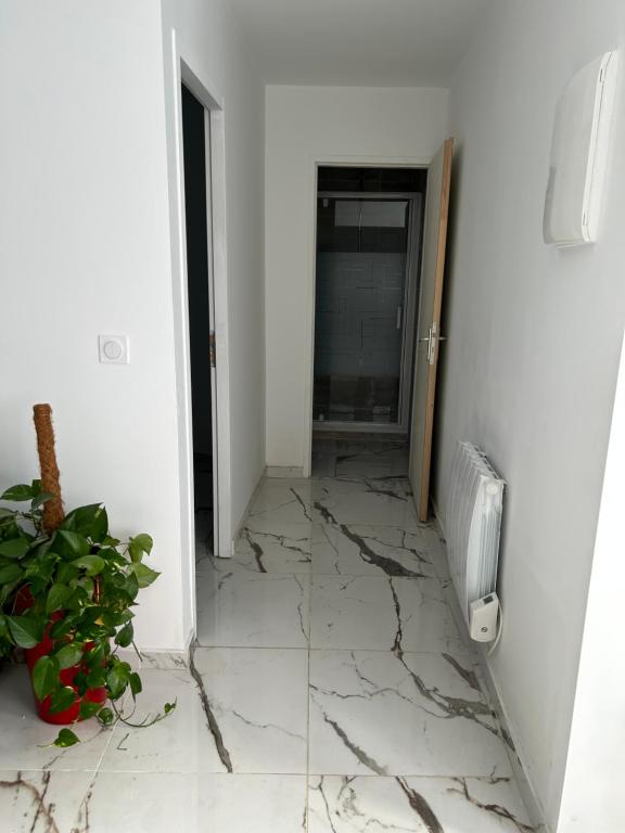 a room with a cracked floor and a hallway with a heater at logement entier: suite chez Vanessa in Décines-Charpieu