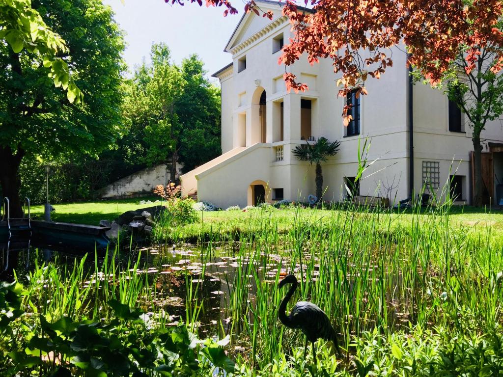 a duck in the grass in front of a building at Villa Palladio - Zimmer in Winden am See