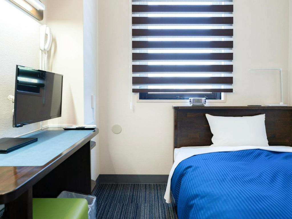 - une chambre avec un lit et un bureau avec un moniteur dans l'établissement HOTEL MARINEPIA - Vacation STAY 92229v, à Shinkamigoto