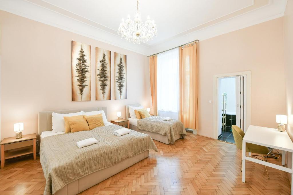 a bedroom with two beds and a desk at Stunning Charles Bridge Apartment in Prague