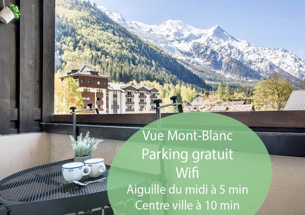 a table on a balcony with a view of a mountain at Au Pied Du Mont-Blanc - Chamonix in Chamonix-Mont-Blanc