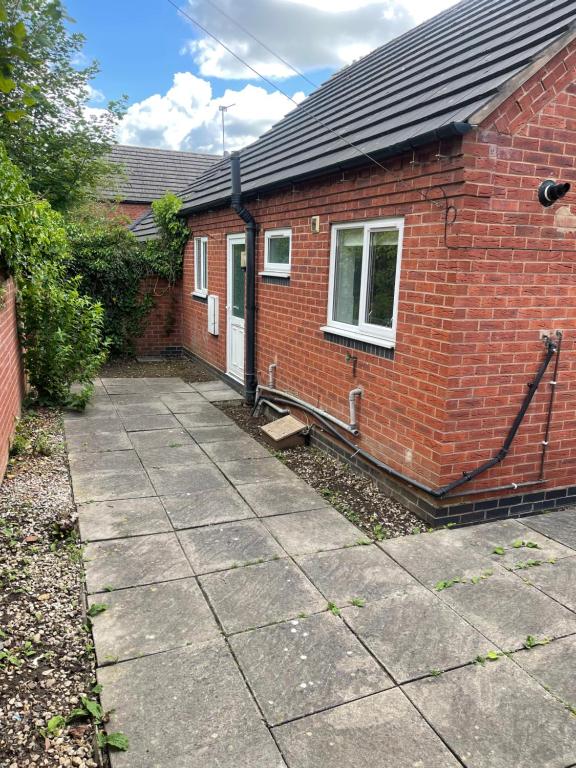 une maison en briques rouges avec un trottoir devant elle dans l'établissement Family Bungalow sleeps 4, à Wellington