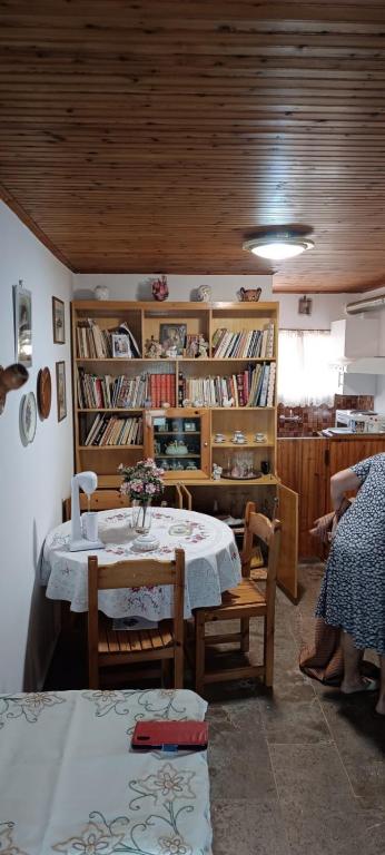 a room with a table and chairs and book shelves at Athina Country House in Kouramádes