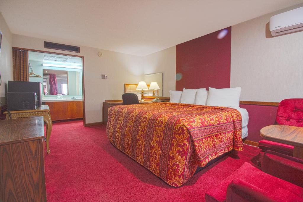 ein Hotelzimmer mit einem Bett und einem TV in der Unterkunft HomeTown Inn By OYO - Liberal, KS in Liberal