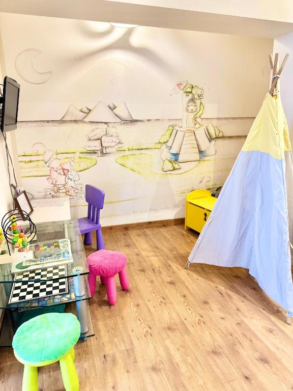 a room with colorful chairs and a wall with a mural at Hotel Las Olas in Noja