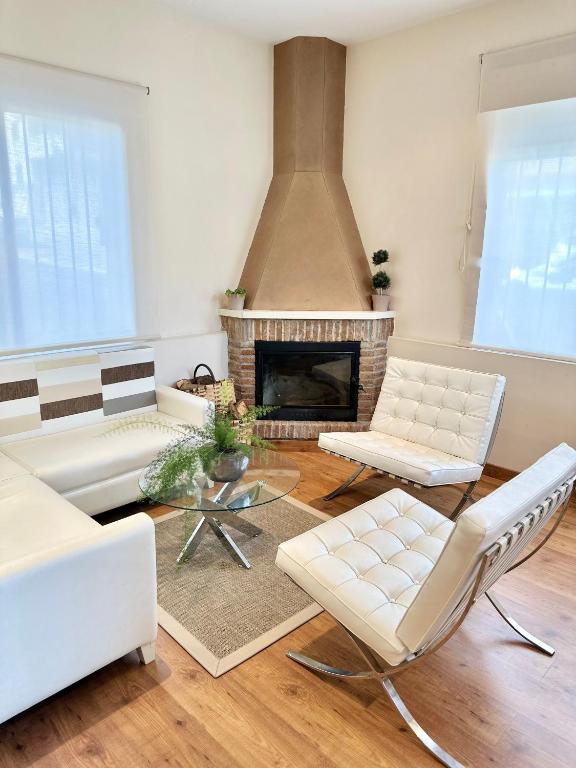 a living room with white furniture and a fireplace at Hotel Las Olas in Noja
