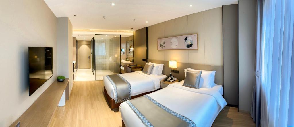 a hotel room with two beds and a bathroom at Zhuo Ruiyunrui Hotel in Dongliucun