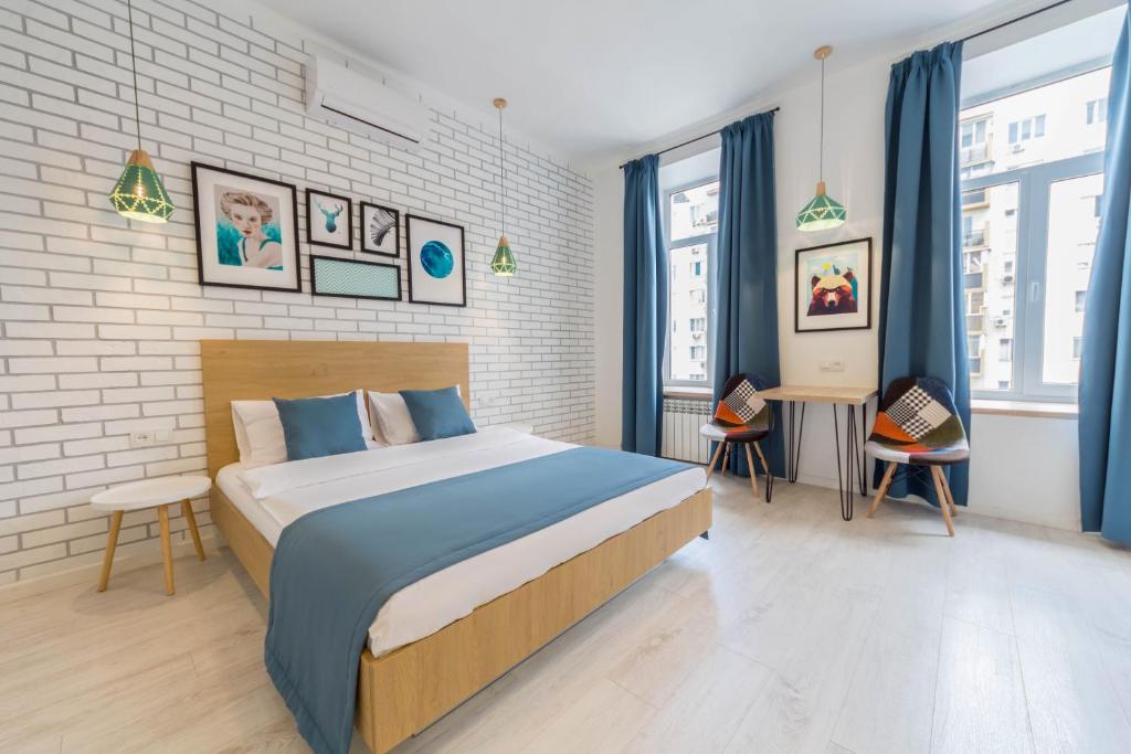 a bedroom with a large bed and some windows at Apartments on Velyka Vasylkivska 47 in Kyiv