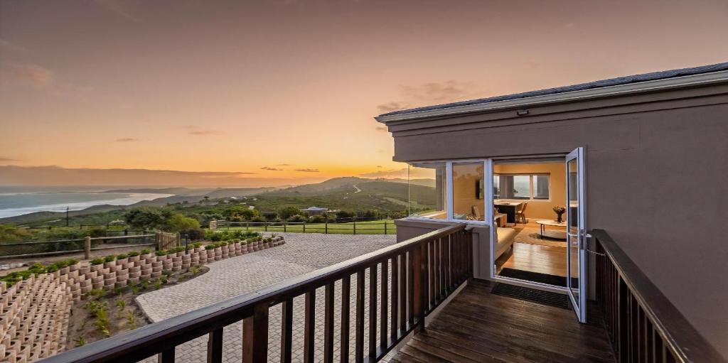 a house with a balcony with a view of the ocean at Pincushion Heights in Brenton-on-Sea